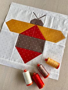 three spools of thread sitting on top of a table next to an ornament