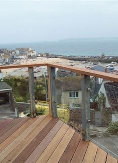 a wooden deck overlooks the ocean and houses