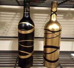 two black and gold wine bottles sitting on a shelf