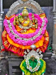 the statue is decorated with flowers and garlands