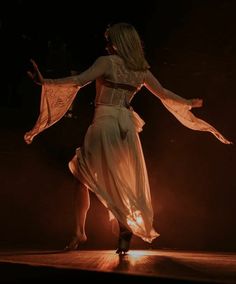 a woman in a white dress dancing on stage