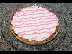 a cake with pink icing sitting on top of a glass plate