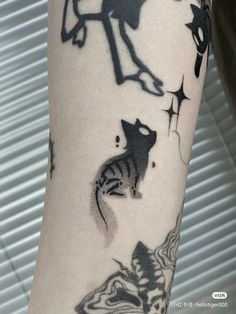 a person with a cat tattoo on their arm and the image is black and white