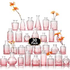 a large collection of pink glass vases and bottles with flowers in them on a white background