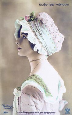 an old fashion photo of a woman wearing a white hat with flowers in her hair