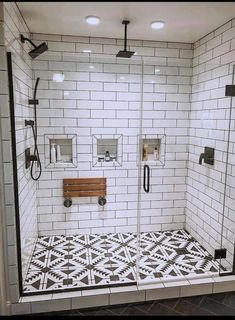 a bathroom with black and white tiles on the floor, shower head, and toilet