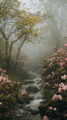 a stream running through a lush green forest filled with lots of pink flowers and trees