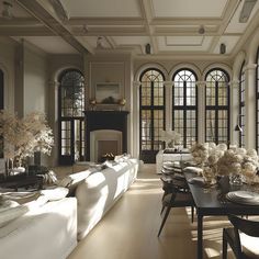 a living room filled with white furniture and lots of windows next to a fire place