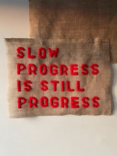 Tapestry art using hessian fabric and red wool. Text is stitched into the hessian using red wool with the words ‘SLOW PROGRESS IS STILL PROGRESS’. The hessian art piece is hung up on a blank wall. Slow Aesthetic, Progress Aesthetic, Slow Progress Is Still Progress, Slow Progress, Right Time, In The End, Portfolio, Instagram Photos, Photo And Video