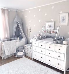 a baby's room with white furniture and hearts on the wall