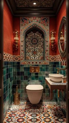 an ornate bathroom with red walls and blue tiles on the floor, along with a white toilet and sink