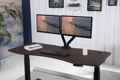 two computer monitors sitting on top of a wooden desk