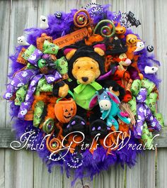 a wreath made out of stuffed animals and other halloween decorations on a wooden fence with the words trick or treat written above it