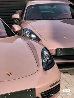 two pink sports cars parked next to each other