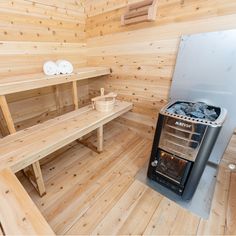 a stove and benches in a wood - paneled room with wooden flooring on the walls