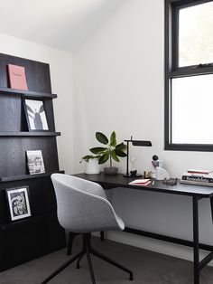 an office with a desk, chair and bookshelf in the corner next to a window