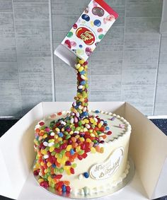 a birthday cake decorated with candy and candies in a box on top of a table