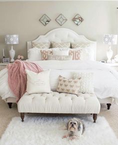 a white bed sitting in a bedroom next to a window