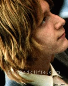 a man with long blonde hair wearing a white shirt and tie looking off into the distance