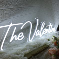 the valentine's sign is lit up with flowers