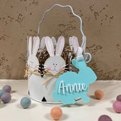 an easter basket with two bunny bunnies in it and the name annie on top