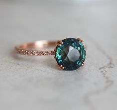 a close up of a ring with a blue stone on it's side and diamonds around the band