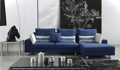 a living room with blue couches and white pillows