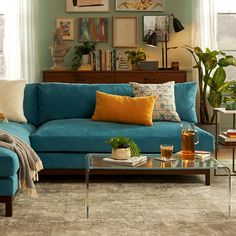 a living room with blue couches and various pictures on the wall above coffee table