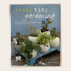 a book with plants in white vases sitting on a table