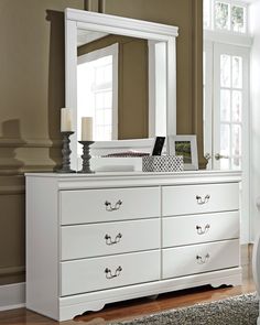 a white dresser and mirror in a room