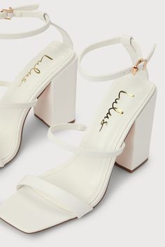 Lulus Exclusive! We just met the Lulus Mabie White Ankle Strap High Heel Sandals, and we're going crazy for how chic they are! Smooth faux leather shapes a square toe upper, a toe strap, and a vamp strap (with a bit of elastic at the side) that rises to an adjustable ankle strap with a shiny gold buckle. A trendy block heel makes these sandals easy to strut your cute self! 4. 25" wrapped block heel. Cushioned insole. Rubber sole has nonskid markings. Man made materials. Imported. Lulus | Mabie W Chic Square Toe Heels With Wrapped Heel, Chic Block Heels With Single Toe Strap For Party, Summer Heels With 4-inch Square Toe, Chic Party Block Heels With Single Toe Strap, Chic 4-inch Heeled Square Toe Shoes, Synthetic Block Heels With Wrapped Heel And Square Toe, Chic Square Toe Block Heels, Trendy Square Toe Heels With Stacked Heel, Square Toe Block Heels With 4-inch Heel For Summer