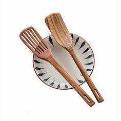 two wooden utensils sitting on top of a white and blue plate next to each other