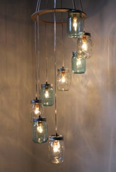 mason jar chandelier with lights hanging from it's sides in a room