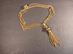 Embrace the allure of timeless elegance with our Antiqued Gold Chain Tassel Necklace. Crafted in a bright and captivating antiqued gold color, this necklace exudes a radiant charm that is sure to make a statement. The necklace features multiple textured cable chains, meticulously designed to create a stunning visual effect. Measuring 20 inches in length, it gracefully drapes along your neckline, adding a touch of sophistication to any outfit. The pendant, measuring 4 inches, showcases a unique clasp, further enhancing its individuality and appeal. With its versatile design, this necklace effortlessly transitions from day to night, making it suitable for both casual and formal occasions. The bright antiqued gold color adds a warm and luxurious touch, elevating your style to new heights. The Gold-tone Chain Necklace For Wedding, Elegant Gold Tassel Jewelry, Elegant Gold Jewelry With Tassels, Gold-tone Wedding Necklace With Chain Detail, Gold Tassel Dangle Necklace, Antique Chain Necklace For Wedding, Gold Tassel Jewelry For Evening, Elegant Gold Long Tassel Necklace, Elegant Long Gold Tassel Necklace