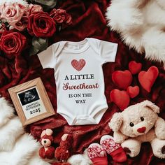 a little sweetheart is on the way baby onesuit with teddy bears and roses next to it