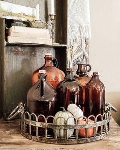 some brown jugs are sitting in a basket on a table next to a mirror