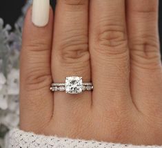 a woman's hand with a ring on it and a diamond in the middle