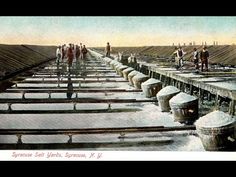 an old photo of people standing on top of rows of water tanks in the snow