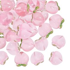 pink glass beads with green leaves on them are scattered in the shape of hearts and flowers