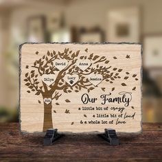 a wooden plaque with an image of a family tree and the words our family on it