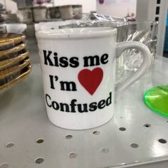 a coffee cup with the words kiss me i'm confused on it