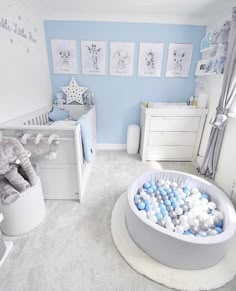 a baby's room is decorated in blue and white with lots of balls on the floor