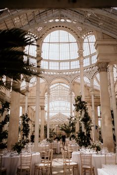 the inside of a building with tables and chairs set up for a formal function in it