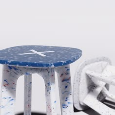 a small blue and white table sitting on top of a wooden floor next to a pair of scissors