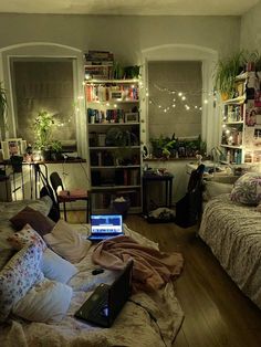 a laptop computer sitting on top of a bed in a room with lots of furniture