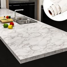 a white marble counter top in a kitchen next to a sink and cutting board with vegetables on it