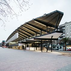 an empty parking lot in front of a large building with lots of windows and balconies