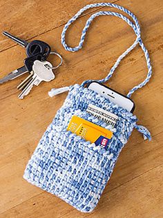 a cell phone and keys on a wooden floor next to a purse with a credit card in it