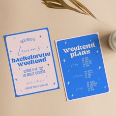 two blue and white flyers sitting on top of a table next to a vase filled with flowers