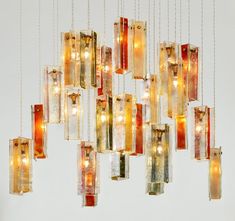 a chandelier made out of glass blocks with lights hanging from the bottom and sides